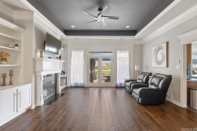 living room with ceiling fan, french doors, crown molding, dark wood-style floors, and a glass covered fireplace