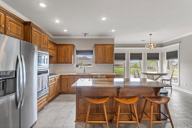 kitchen with a sink, appliances with stainless steel finishes, brown cabinetry, and recessed lighting