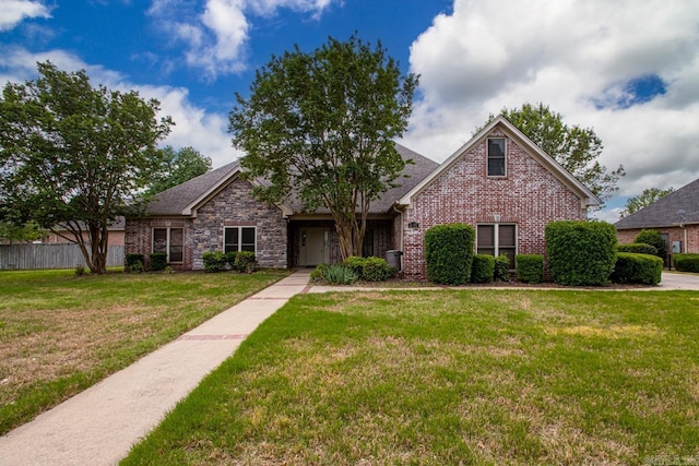 view of front of property with brick siding, fence, and a front yard