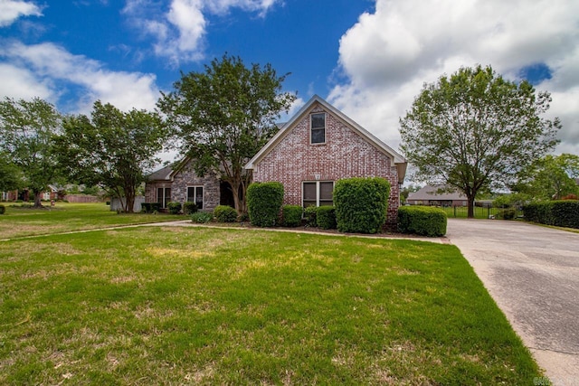 view of front of property featuring brick siding and a front yard