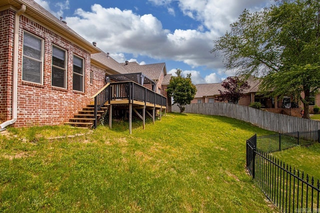 view of yard featuring a wooden deck, stairs, and a fenced backyard