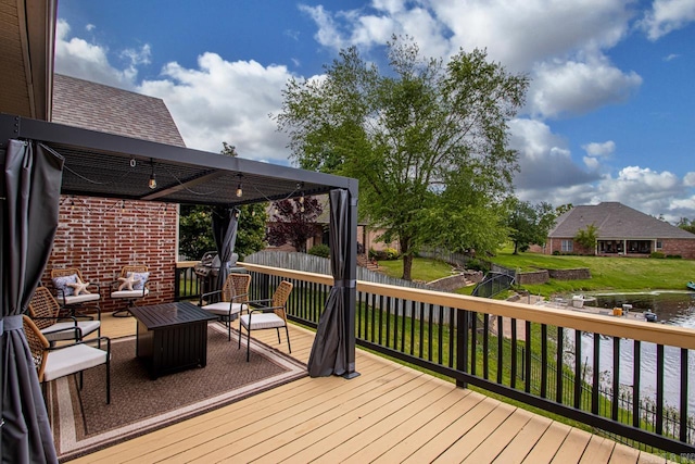 deck featuring a yard, a water view, and fence