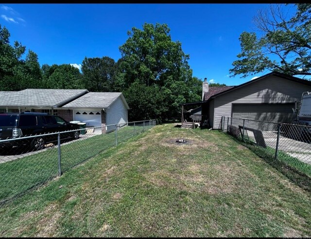 view of yard with an attached garage and fence