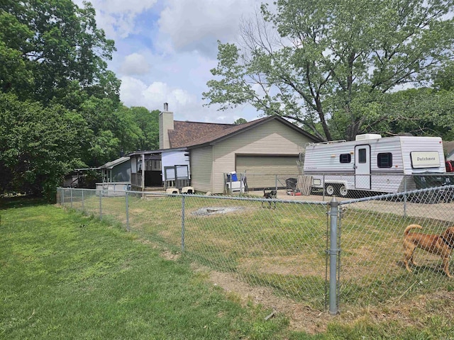 view of side of home featuring a yard, fence, and a chimney
