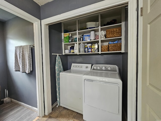 laundry area with washing machine and clothes dryer, baseboards, and laundry area