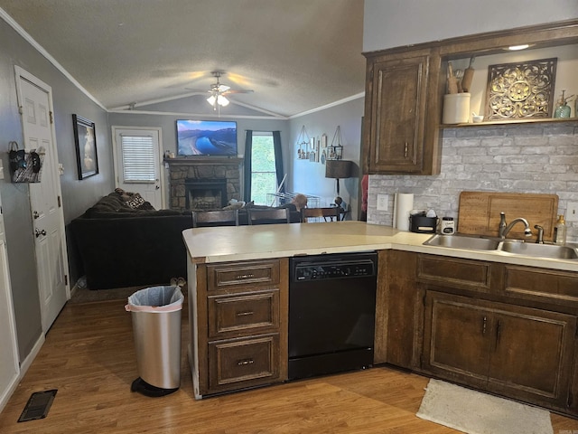 kitchen with a sink, a peninsula, visible vents, dishwasher, and crown molding