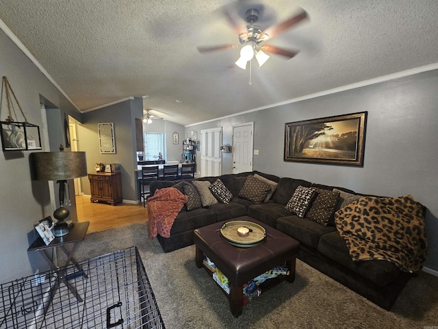 living area with a ceiling fan, lofted ceiling, a textured ceiling, ornamental molding, and light colored carpet
