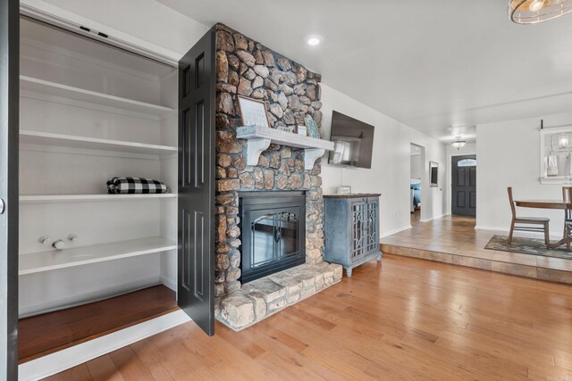 203 Stearns Pt Unit B6, Lake Hamilton, AR 71913 - unfurnished living room featuring baseboards, a stone fireplace, and wood finished floors