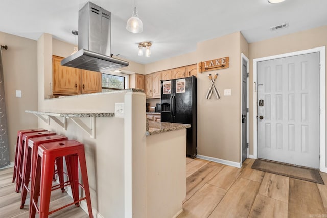 203 Stearns Pt Unit D1, Lake Hamilton, AR 71913 - kitchen featuring a breakfast bar area, island range hood, light wood-type flooring, visible vents, and black fridge with ice dispenser