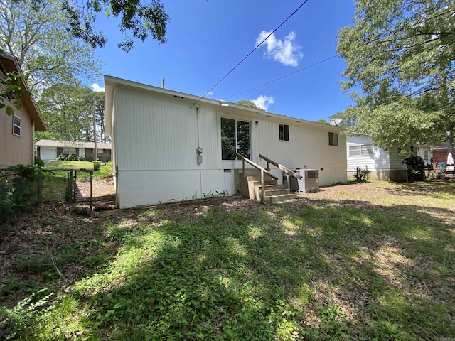 rear view of house featuring crawl space, central air condition unit, fence, a yard, and entry steps