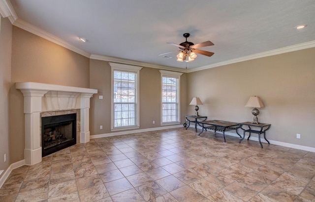 living area featuring crown molding, a ceiling fan, baseboards, and a tiled fireplace