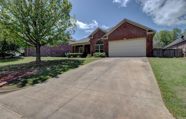 ranch-style home featuring an attached garage, concrete driveway, a front lawn, and brick siding