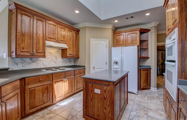 kitchen with white appliances, brown cabinetry, visible vents, and ornamental molding