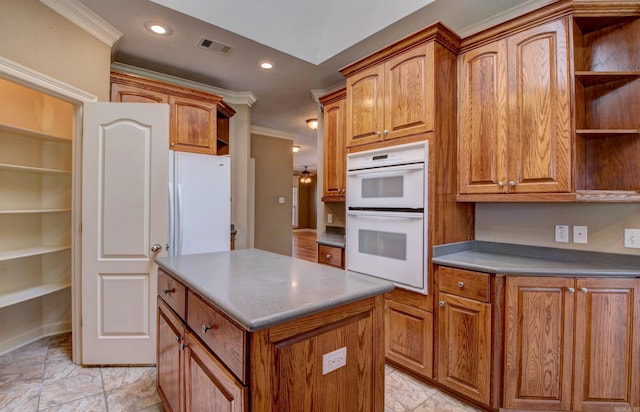 kitchen with visible vents, open shelves, ornamental molding, a center island, and white double oven