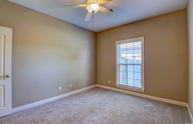 spare room featuring carpet floors, a ceiling fan, baseboards, and visible vents