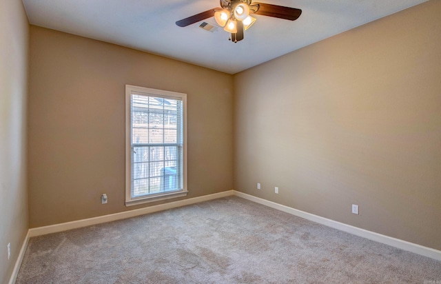 spare room with baseboards, a ceiling fan, carpet, and visible vents
