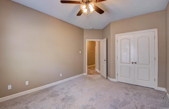 unfurnished bedroom featuring baseboards, a ceiling fan, carpet, and a closet