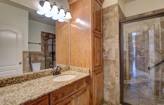 bathroom with vanity, toilet, and a stall shower