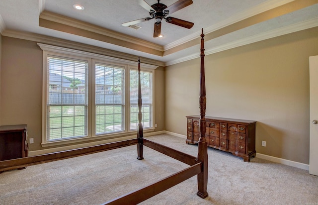unfurnished bedroom featuring carpet floors, a raised ceiling, crown molding, and baseboards