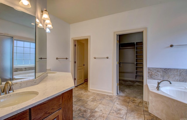 bathroom with vanity, a garden tub, and a walk in closet