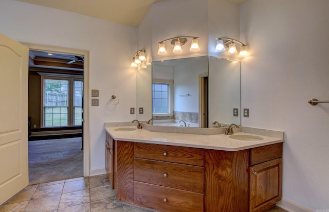 bathroom with double vanity, baseboards, a sink, and a bath