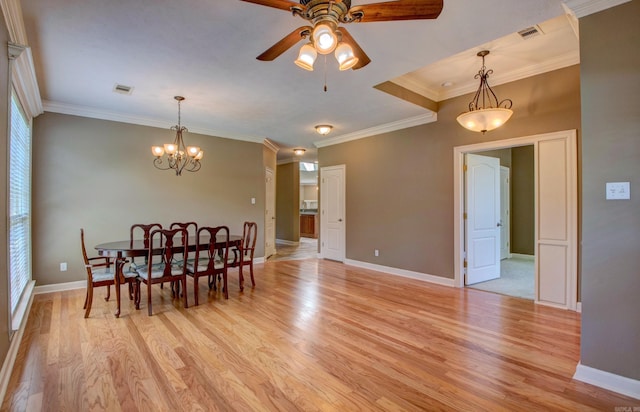 dining area with light wood-style flooring, ceiling fan with notable chandelier, baseboards, visible vents, and ornamental molding
