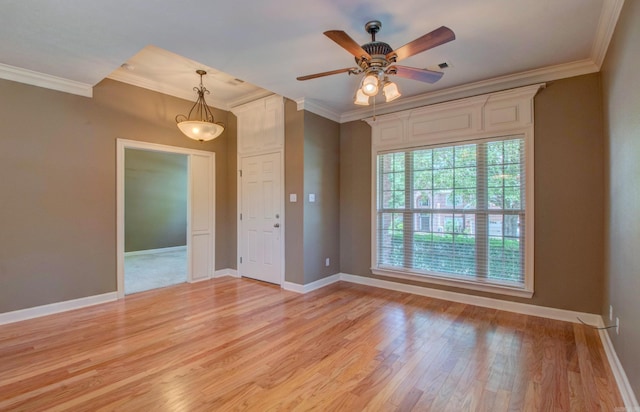 empty room featuring crown molding, a ceiling fan, baseboards, and light wood-type flooring