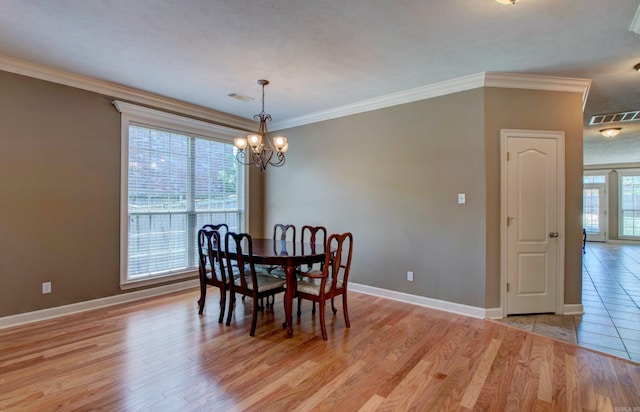 dining space featuring visible vents, light wood-style flooring, baseboards, and a notable chandelier