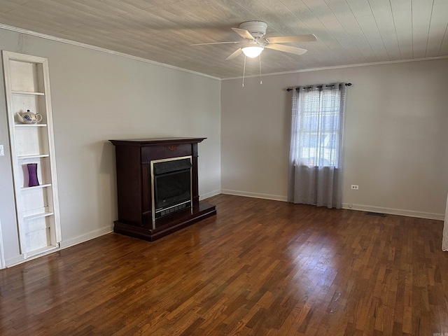 unfurnished living room featuring a fireplace, built in features, ornamental molding, a ceiling fan, and dark wood-style floors