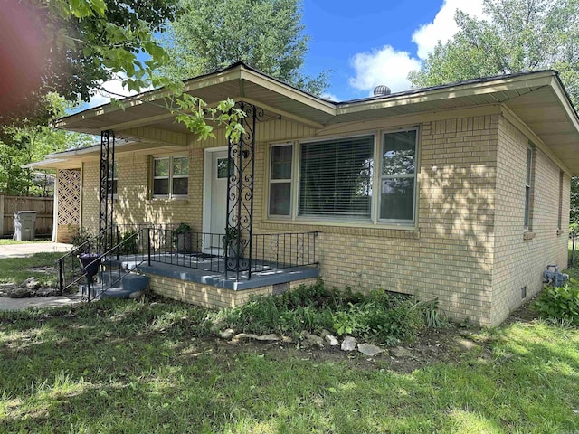 bungalow-style home with a porch, crawl space, and brick siding