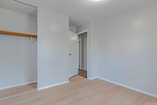 3210 Kingsbury St, Jonesboro, AR 72401 - unfurnished bedroom with a textured ceiling, baseboards, a closet, and wood finished floors