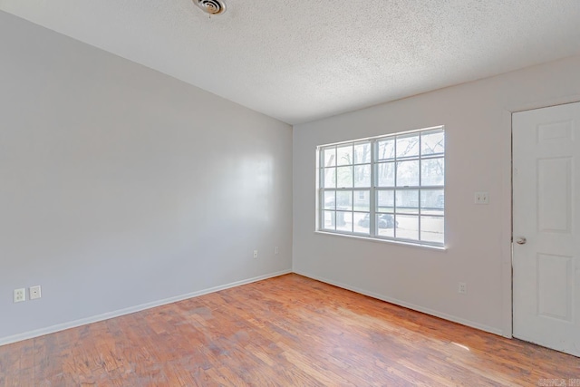 3210 Kingsbury St, Jonesboro, AR 72401 - empty room featuring baseboards, a textured ceiling, and wood finished floors