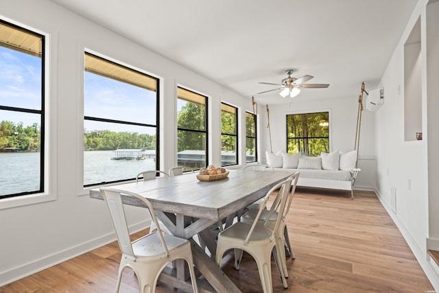 sunroom with an AC wall unit and a water view