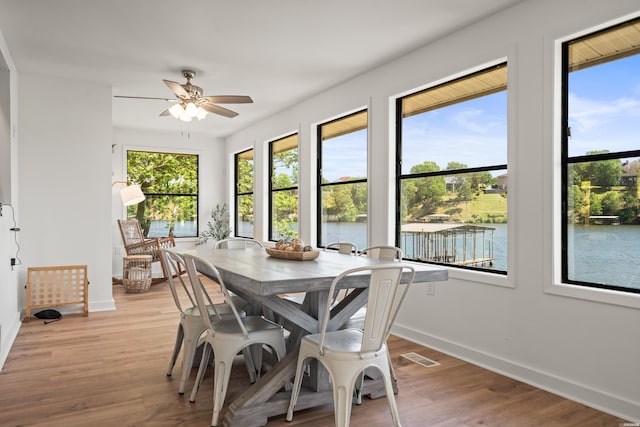 dining space featuring baseboards, ceiling fan, and light wood-style floors