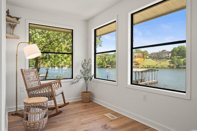 sitting room featuring baseboards, visible vents, a wealth of natural light, and wood finished floors