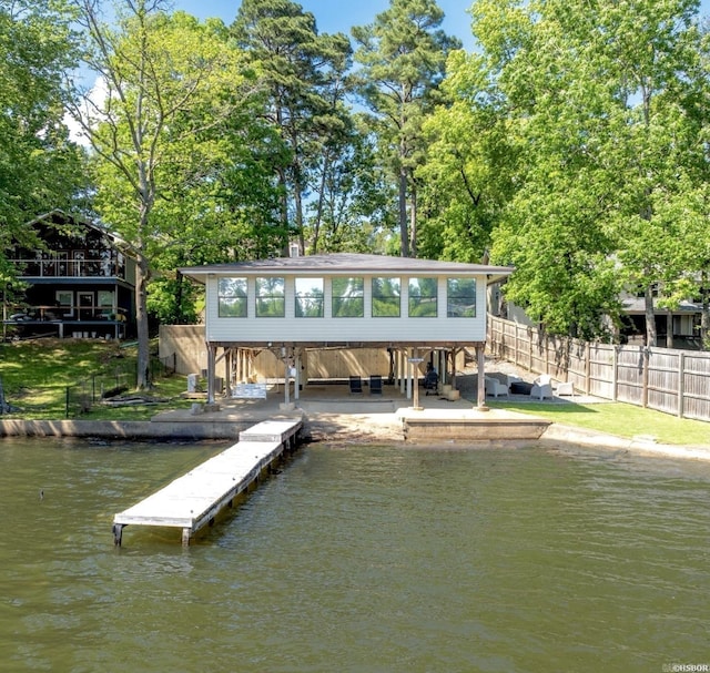 view of dock with stairs, fence, and a deck with water view