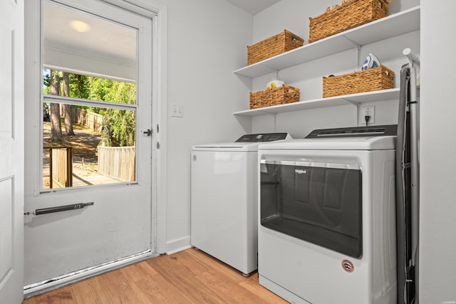 clothes washing area featuring laundry area, light wood finished floors, and separate washer and dryer