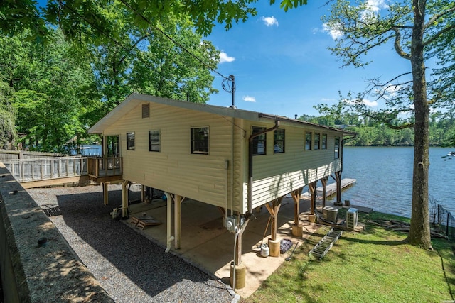 view of side of home with a patio area, central air condition unit, and a deck with water view