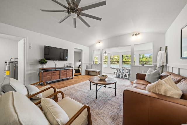 living room with light wood-style floors, ceiling fan, vaulted ceiling, and electric water heater