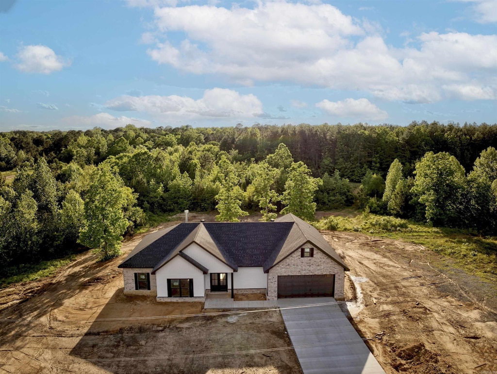 birds eye view of property featuring a view of trees