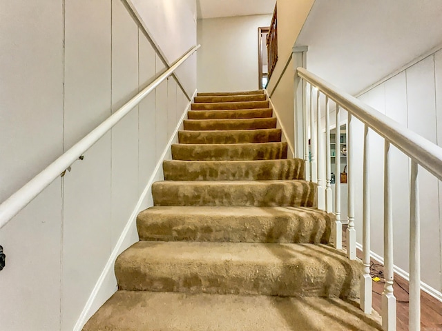 staircase featuring a decorative wall
