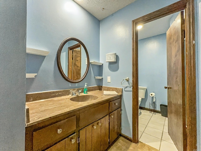 bathroom featuring toilet, a textured ceiling, tile patterned flooring, and vanity