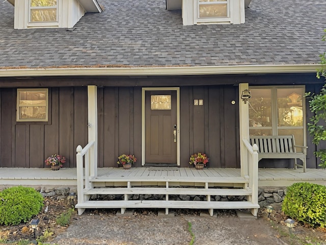 doorway to property featuring roof with shingles and board and batten siding