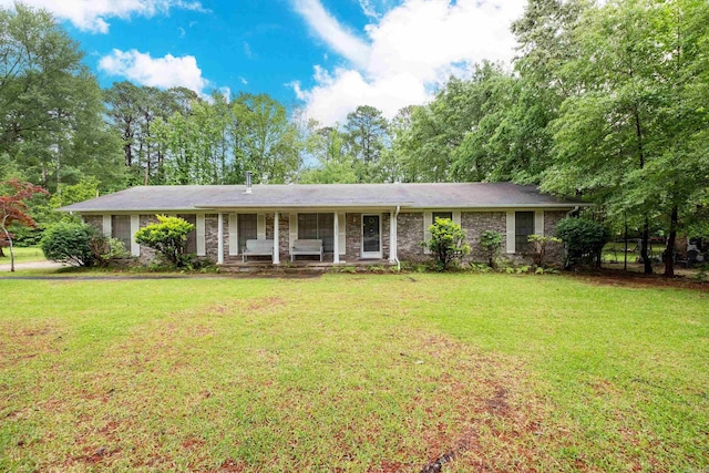 ranch-style home with covered porch and a front yard
