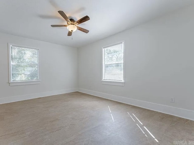 unfurnished room featuring a healthy amount of sunlight, baseboards, and ceiling fan