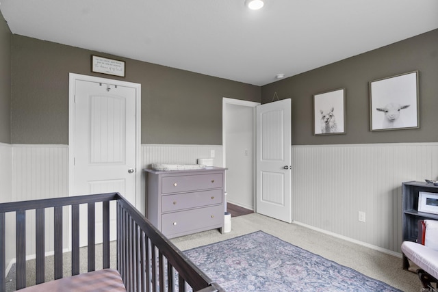 bedroom with a wainscoted wall and carpet floors