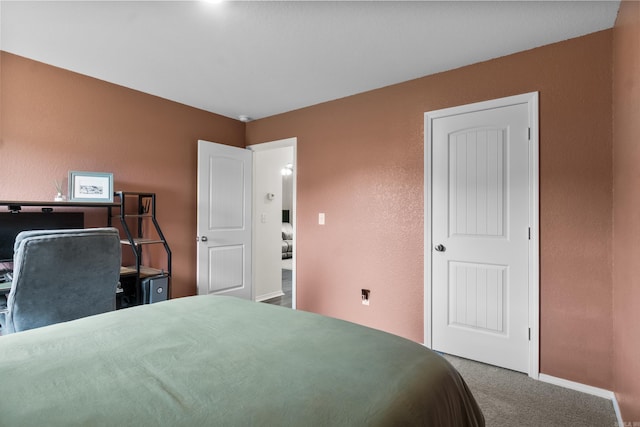 bedroom featuring baseboards, carpet, and a textured wall