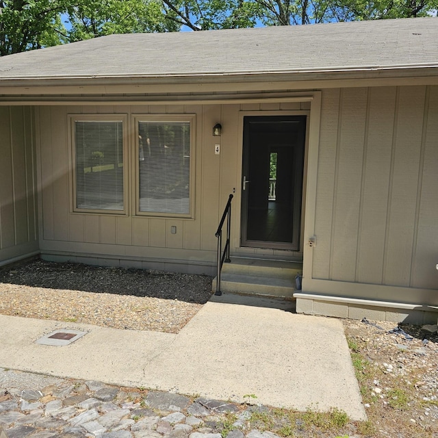 doorway to property featuring a shingled roof