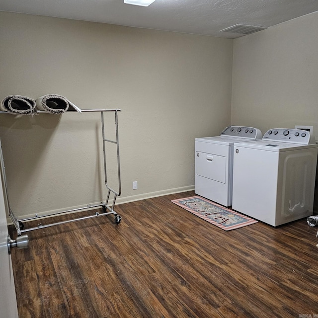 laundry area with baseboards, laundry area, wood finished floors, and washer and clothes dryer