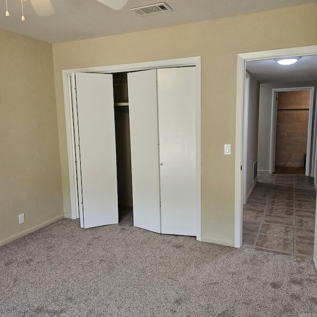 unfurnished bedroom with visible vents, carpet floors, and a closet